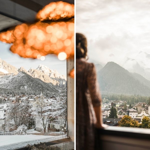 Wellnesshotel in Südtirol: Auf in den Traumurlaub! Blick aus einem Fenster auf ein verschneites Bergdorf und auf ein Dorf im Herbst