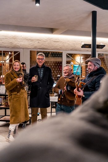 Weekly programme of the “Wanderhotels Südtirol” People gathered outdoors at night drinking and playing music