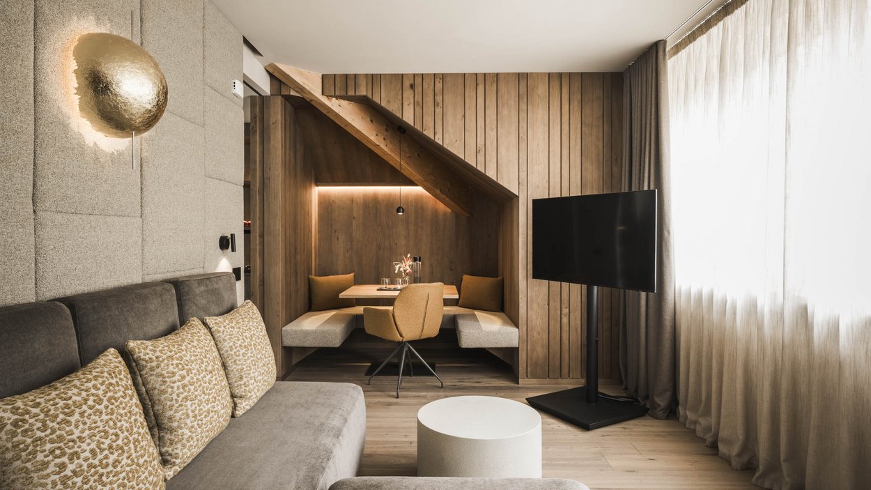 #myexcelsior Sunday News 16.03.2025 Gemütliches Wohnzimmer mit Ecke-Sitzbereich, Sofa, TV und Holzwandverkleidung