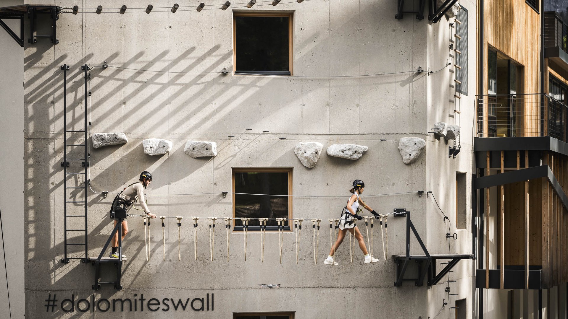 Weekly programme of the “Wanderhotels Südtirol” Two people climbing a vertical wall with harnesses and safety ropes