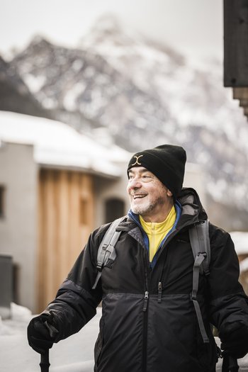 Il nostro hotel sulle piste a San Vigilio di Marebbe Uomo anziano con abbigliamento invernale e bastone da trekking in montagna