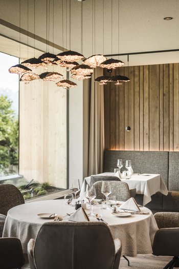 Wellnesshotel in Südtirol: Auf in den Traumurlaub! Modernes Restaurant mit Panoramafenster und Blick auf Berge