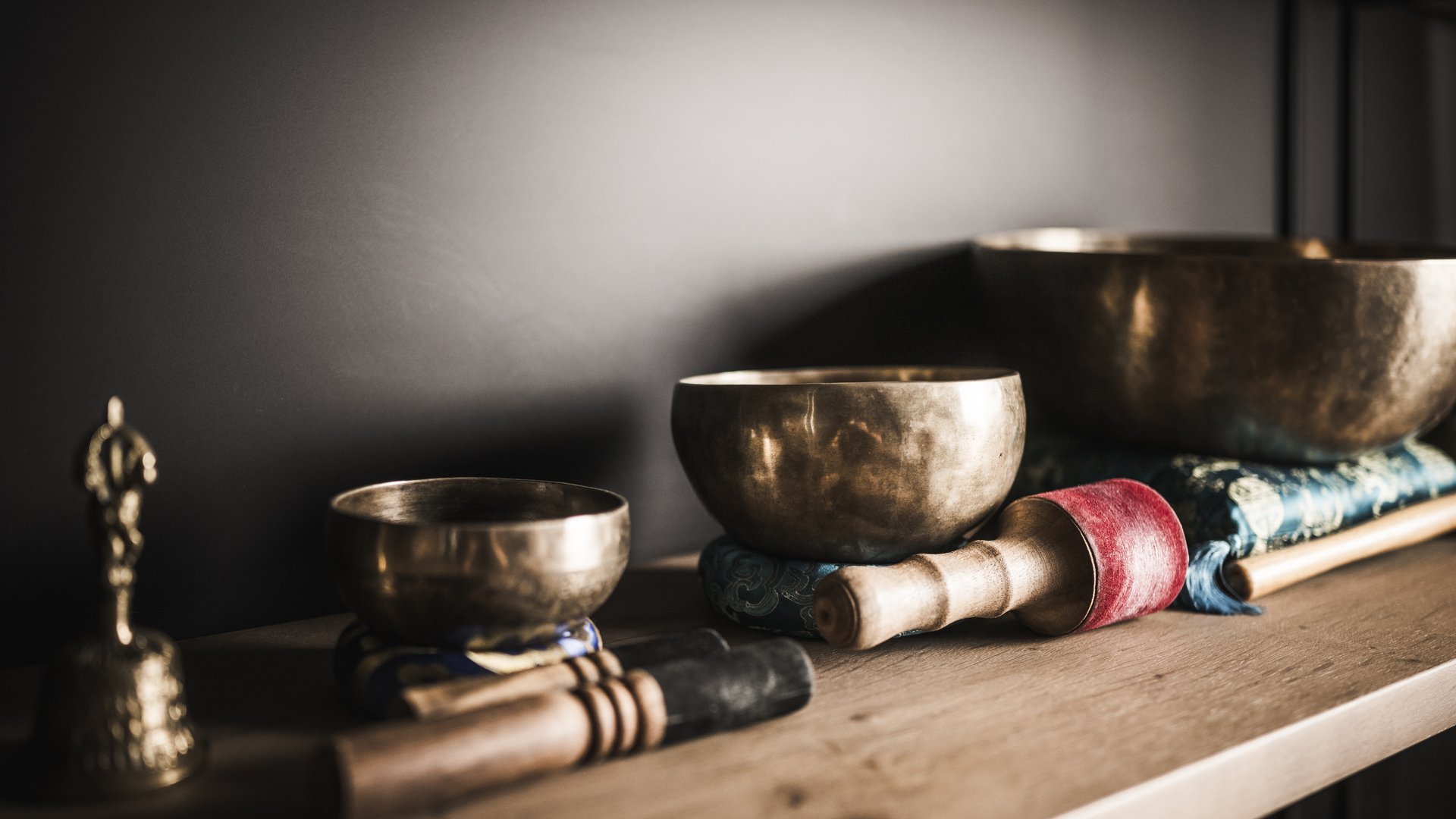 Weekly programme of the “Wanderhotels Südtirol” Three Tibetan singing bowls with mallets on wooden table