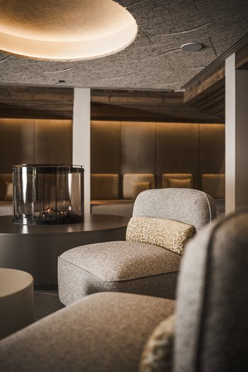 Wellnesshotel in Südtirol: Auf in den Traumurlaub! Gemütlicher Sitzbereich mit Kamin und gedämpfter Beleuchtung