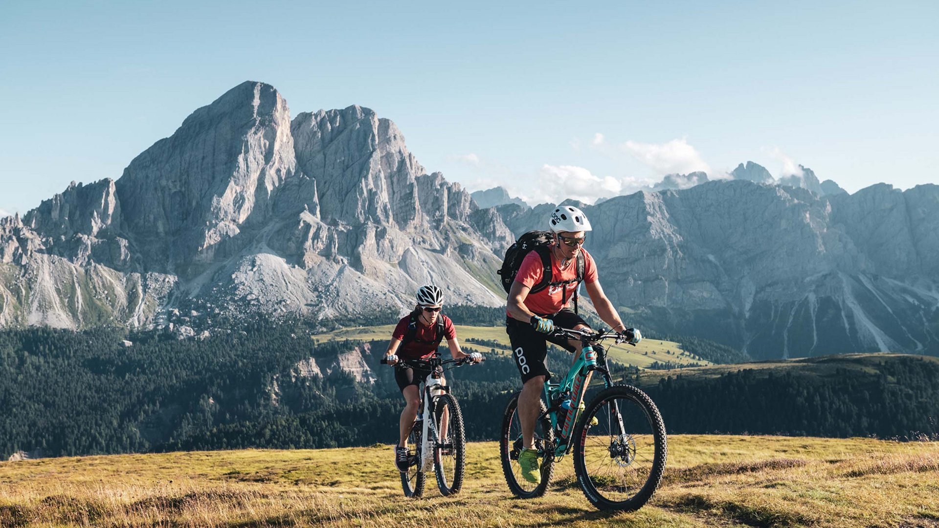 Bike-Leistungen Zwei Mountainbiker fahren auf einem Bergweg mit Alpen im Hintergrund