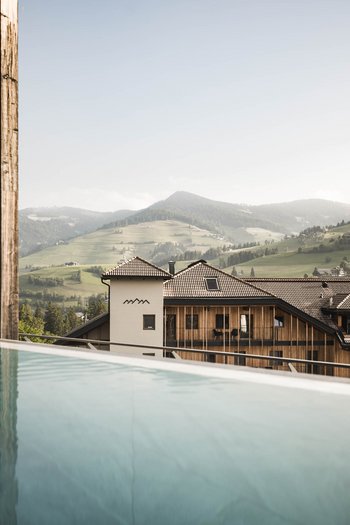 Wellnesshotel in Südtirol: Auf in den Traumurlaub! Modernes Haus mit Pool und Bergblick in sonniger Landschaft