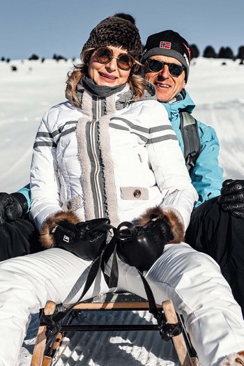 Weekly programme of the “Wanderhotels Südtirol” Couple sledding on snowy hill on a sunny day