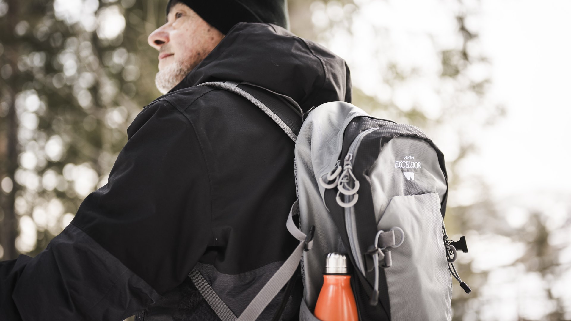 Weekly programme of the “Wanderhotels Südtirol” Older man wearing black jacket and gray backpack in the forest